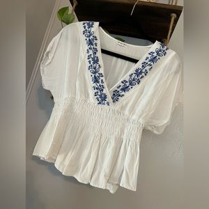 White blouse with blue floral design and cinched waist